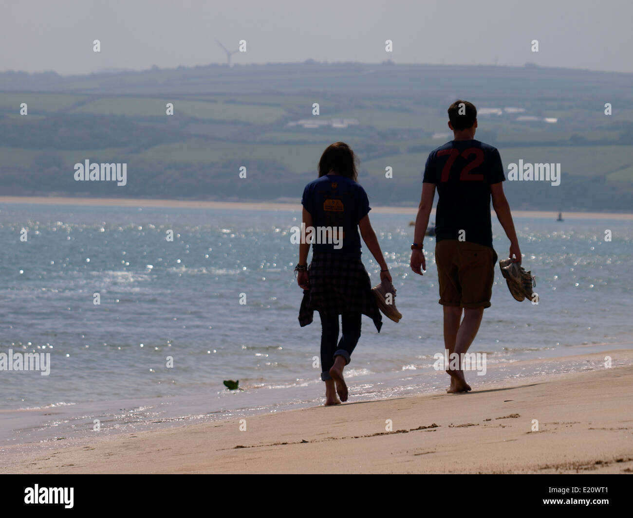 Junges Paar barfuß entlang dem Strand, Padstow, Cornwall, UK Stockfoto