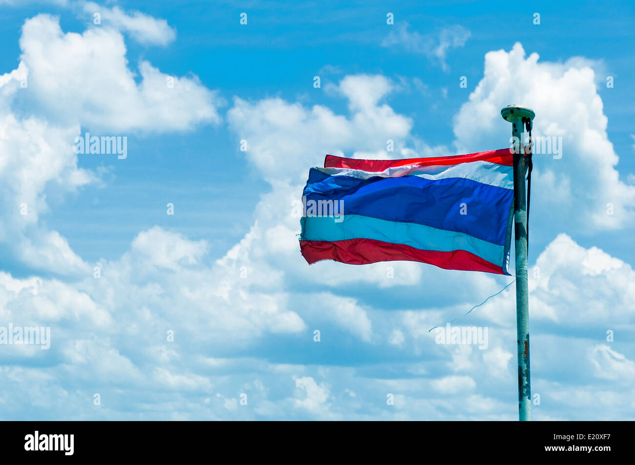wehende thailändische Flagge von Thailand mit blauen bewölkten Himmelshintergrund Stockfoto