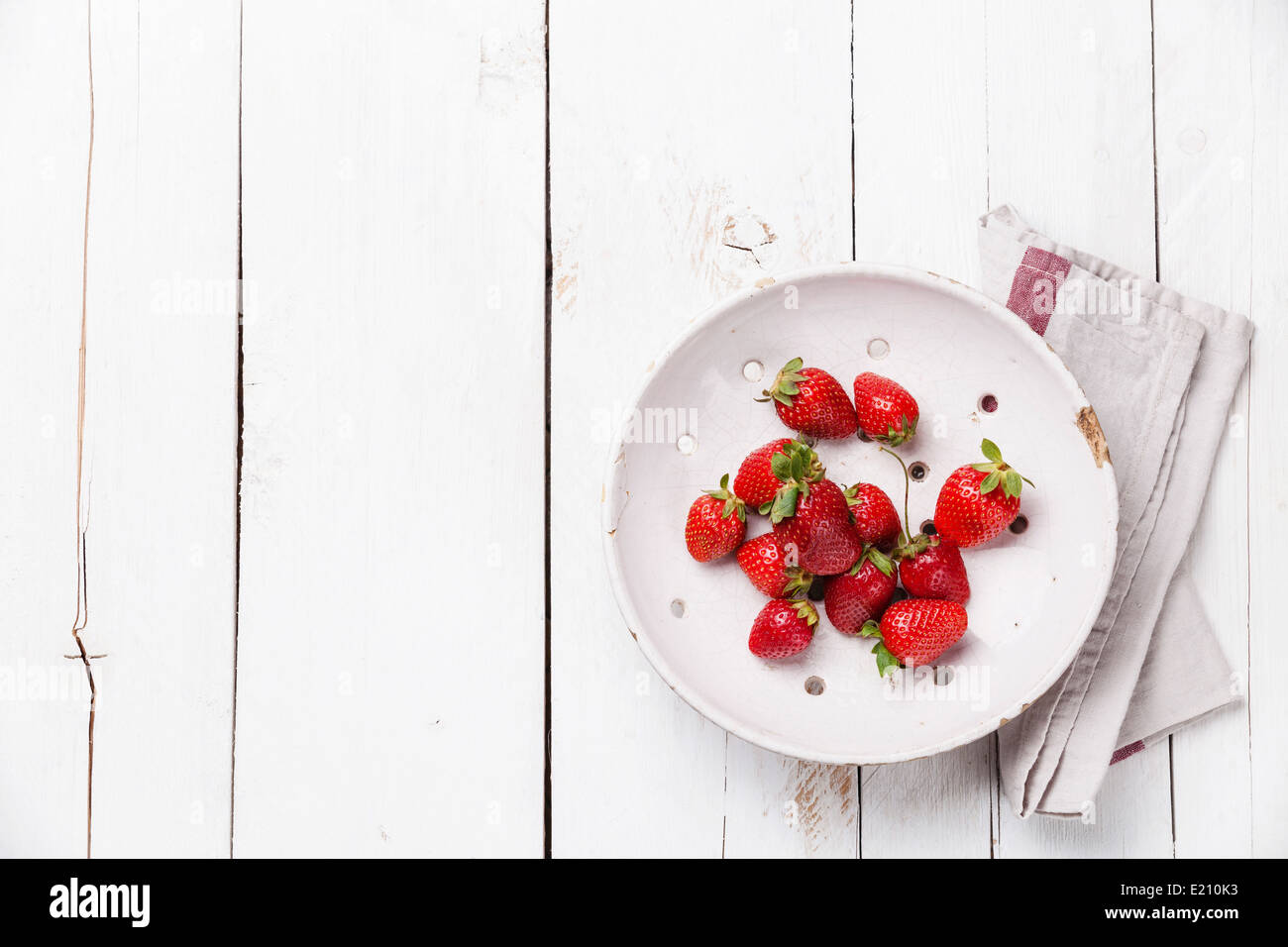 Erdbeere in Vintage Keramik Sieb auf weißem Holz Hintergrund Stockfoto