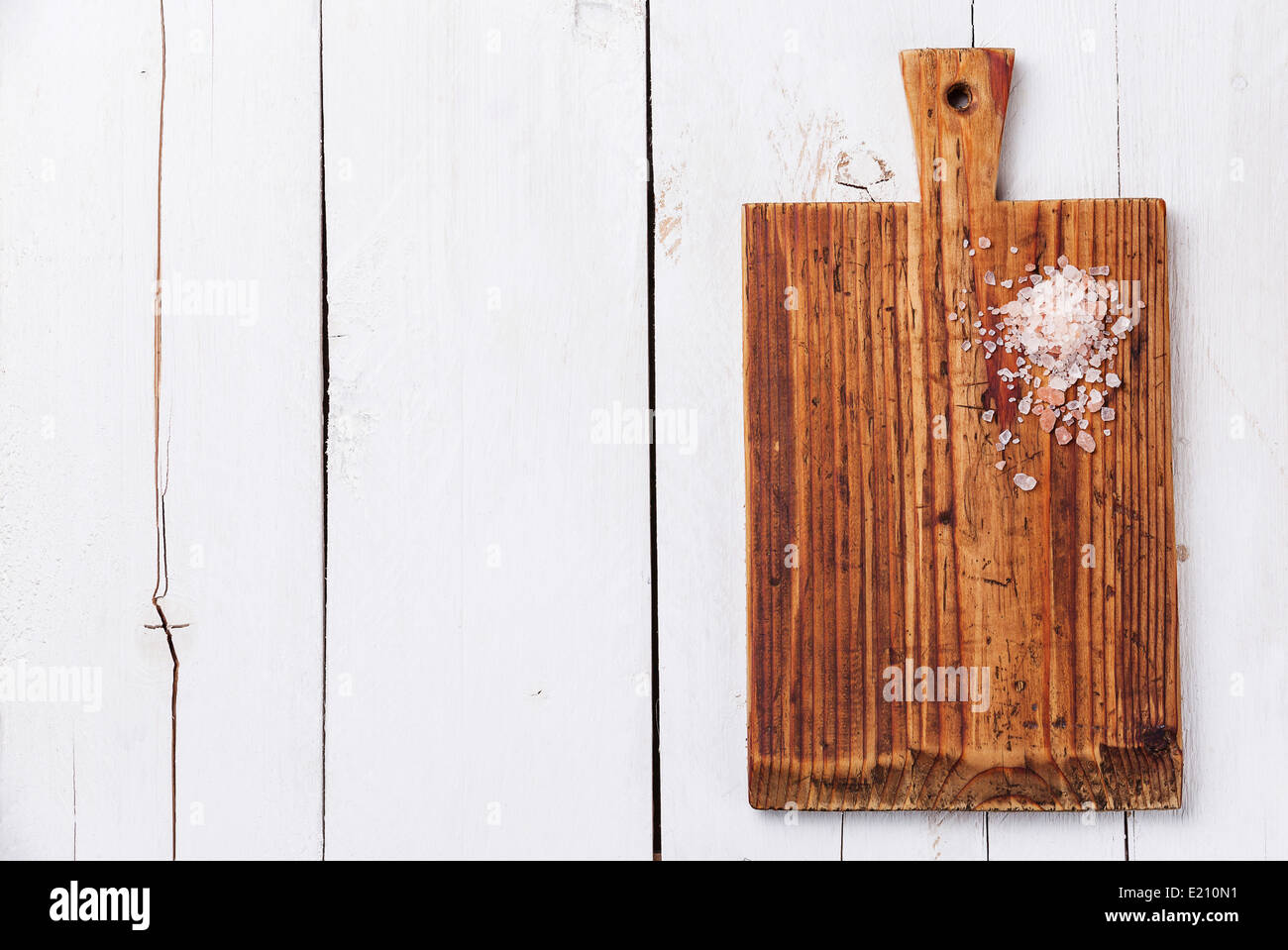 Rosa Salz auf Küche Schneidbrett auf weißem Holz Textur Hintergrund Stockfoto