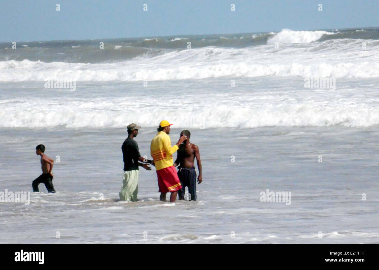Freiwillige zerstreut Menschen, als die Stadt den Zyklon im Hoxbay Bereich in Karachi auf Donnerstag, 12. Juni 2014 Zahnspange. Die Pakistan Meteorological Department am 12. Juni ausgestellt beratender Stimme über die Bildung eines tropischen Zyklons im östlichen arabischen Meer. Stockfoto