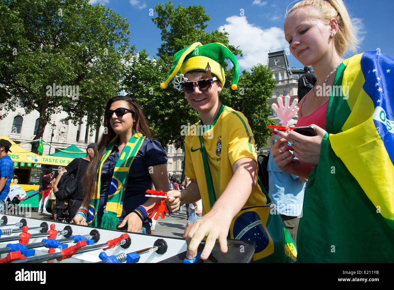 London, UK. Donnerstag, 12. Juni 2014. Spielen Sie Tischfußball. Brasilianer zu sammeln für die Brasilien-Day Feierlichkeiten in Trafalgar Sq. Eine Versammlung zu Beginn der FIFA WM 2014 in Brasilien zu feiern. Feiernden singen und tanzen und spielen Fußball-Spiele und das alles in gelb grün und Blau der brasilianischen Flagge. Bildnachweis: Michael Kemp/Alamy Live-Nachrichten Stockfoto