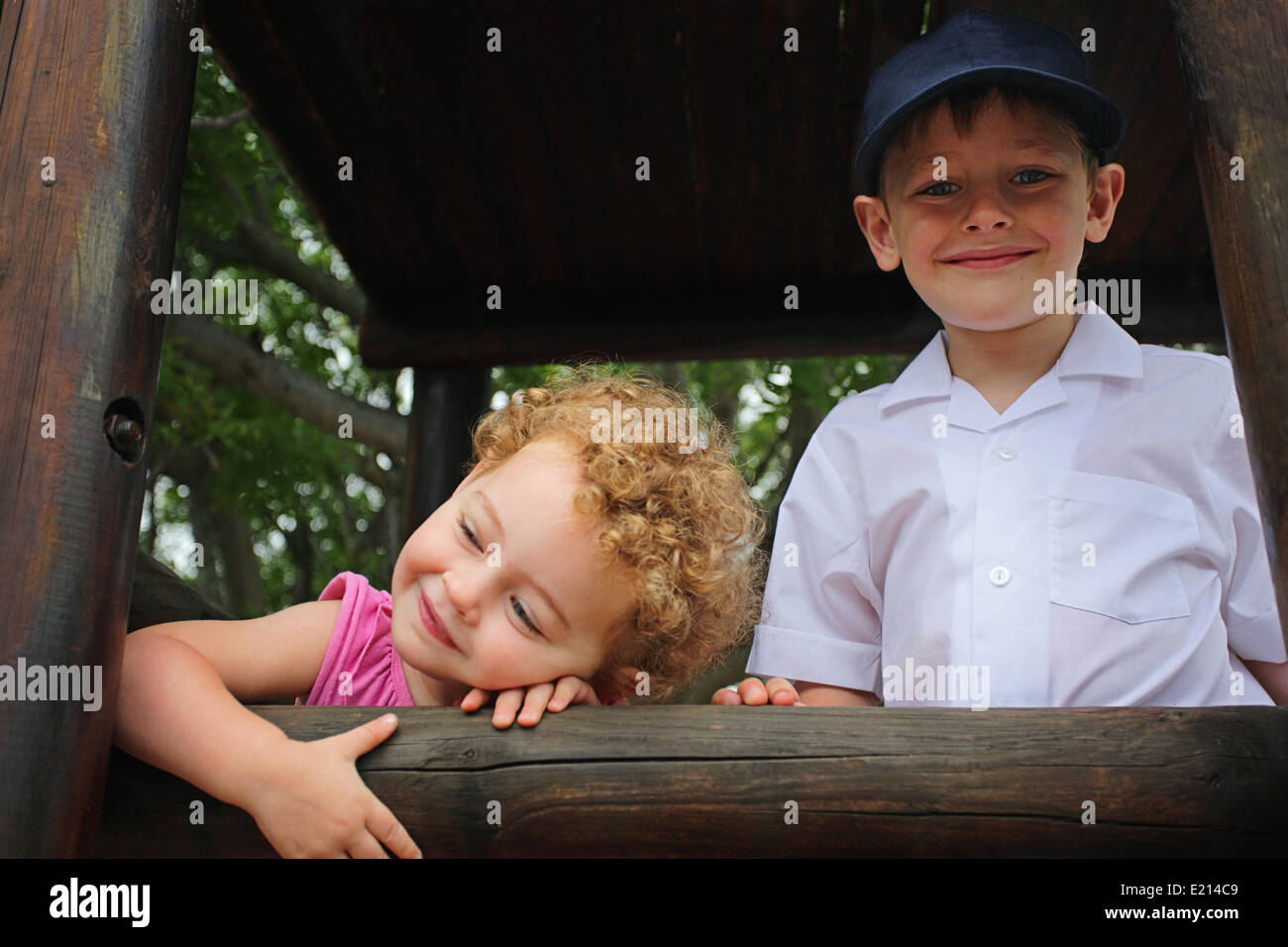 Lächelnd Schuljunge und seine Schwester in ein Klettergerüst auf seinen ersten Tag in der Schule Stockfoto