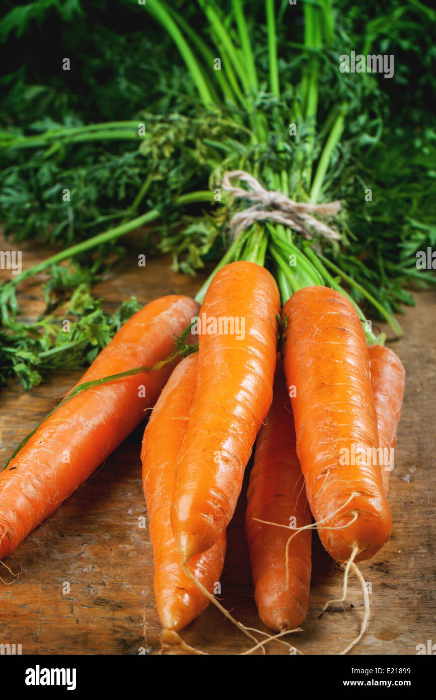 Haufen von frischer Karotte am alten Schneidebrett. Stockfoto