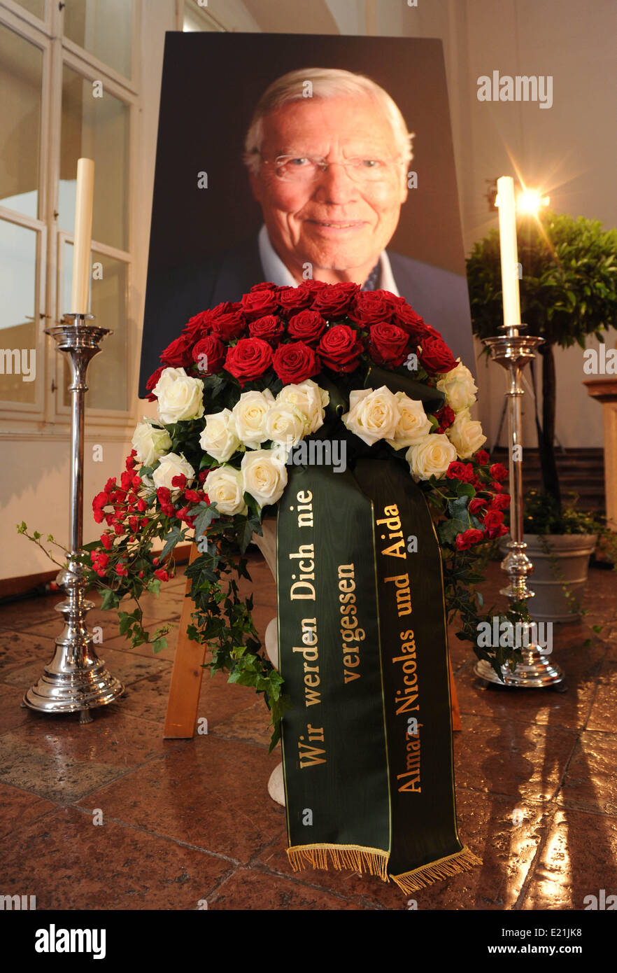 Salzburg, Österreich. 13. Juni 2014. Roten und weißen Rosen und Band das liest, "Wir werden nie vergessen Sie - Almaz, Nicolas und Aida" sind während der Trauerfeier für den verstorbenen Schauspieler am städtischen Friedhof Salzburg in Salzburg, Österreich, 13. Juni 2014 ein Porträt von Karlheinz Böhm vorgesetzt. Der Schauspieler und Gründer der gemeinnützigen Organisation "Menschen Für Menschen" (lit.-Menschen für Menschen) verstarb im Alter von 86 Jahren im Mai 2014. Foto: TOBIAS HASE/Dpa/Alamy Live News Stockfoto