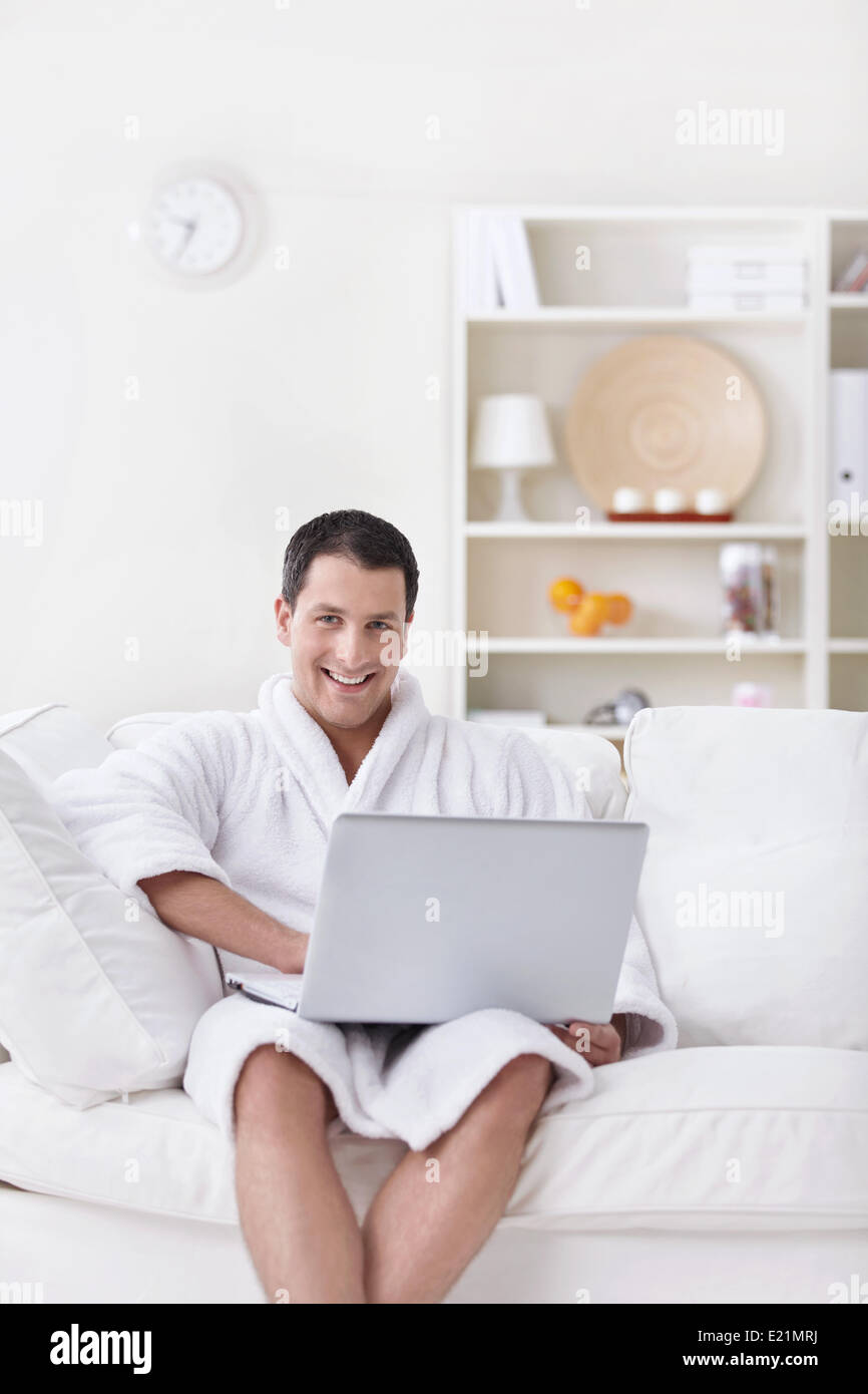 Ein junger Mann in einem weißen Gewand mit laptop Stockfoto