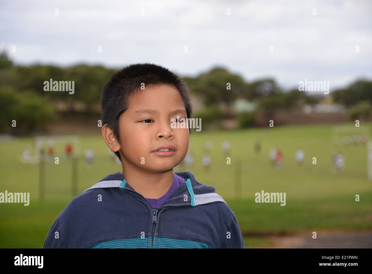 Ein Junge mit einem Hintergrund eines Fußballspiels. Stockfoto