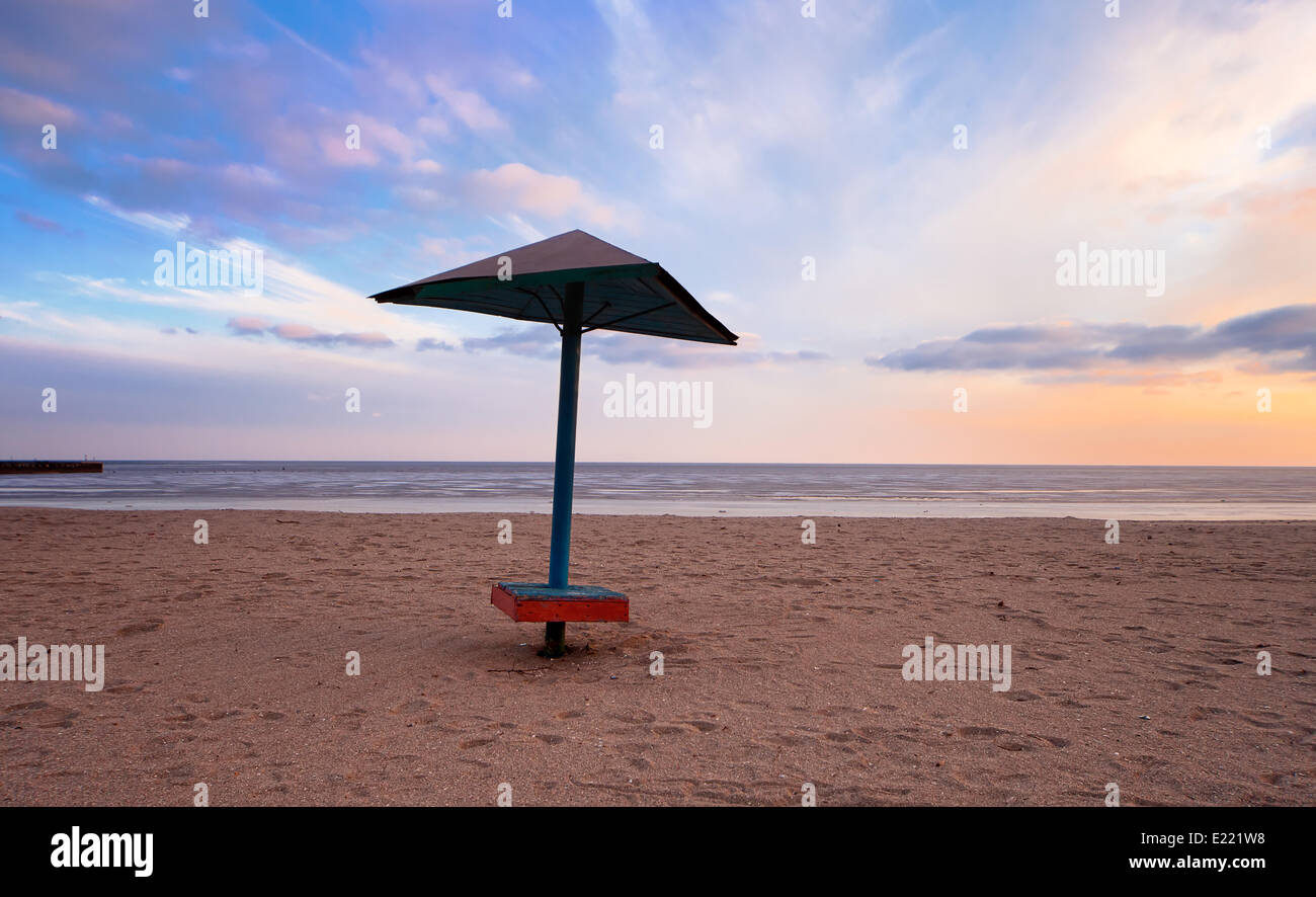 leerer Strand mit einsamen Regenschirm Stockfoto