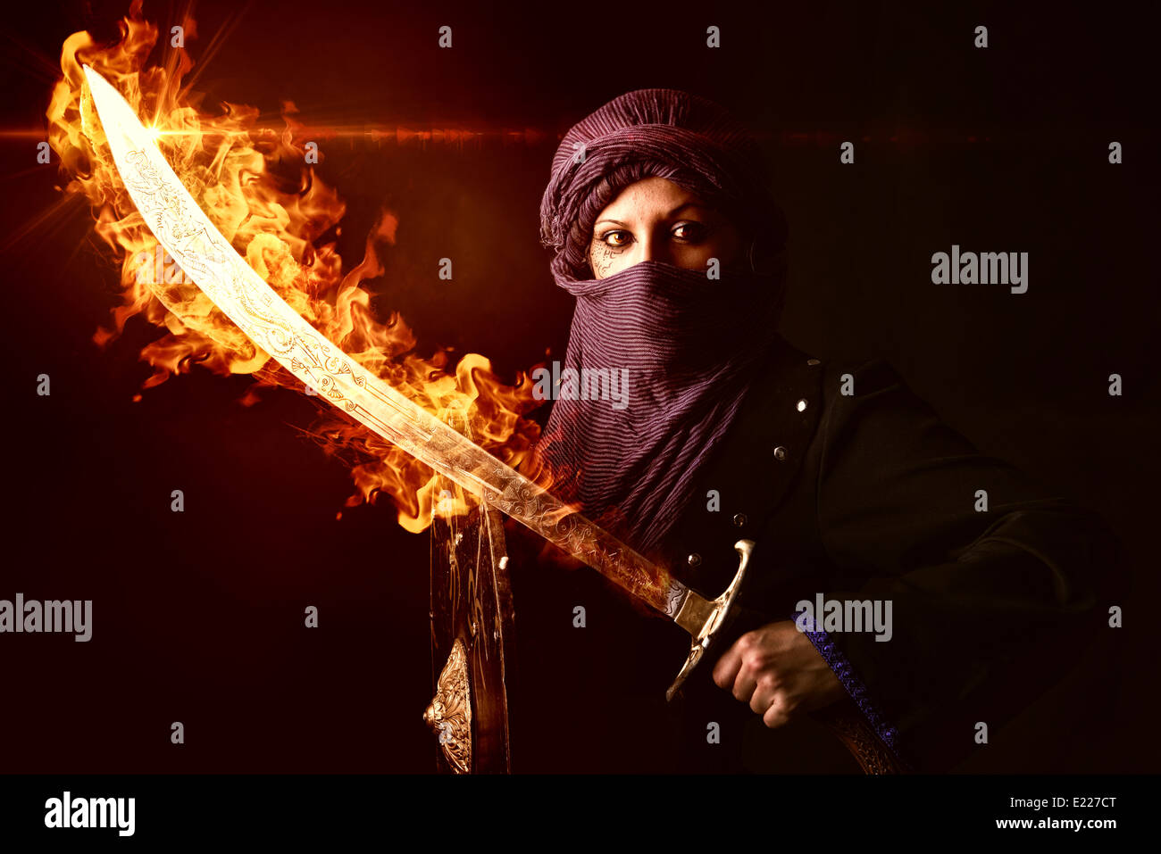 Arabische Frau Krieger mit Schwert auf Feuer vor einem dunklen Hintergrund Stockfoto