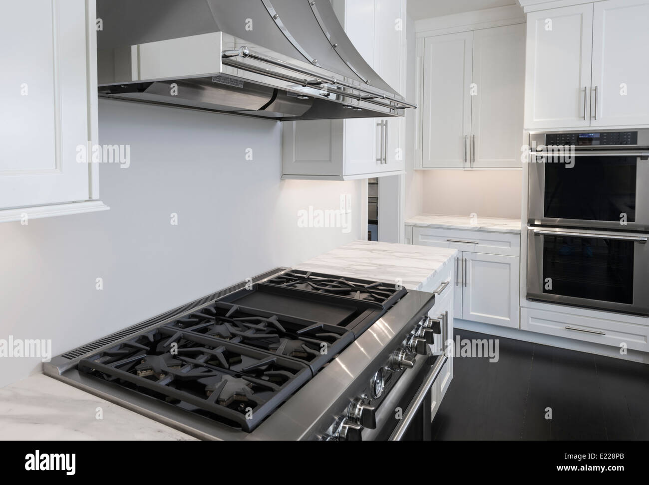 Weiße Küche mit Küchengeräten aus Edelstahl Stockfoto