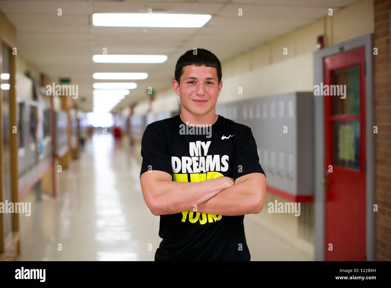 Männlichen High-School senior Student Athleten, Posen im Flur seiner Schule in Austin, Texas Stockfoto