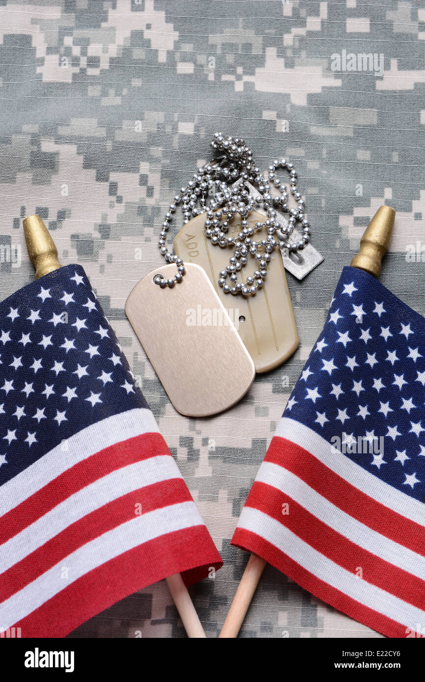 Nahaufnahme von zwei gekreuzten amerikanische Flaggen auf Tarnung Material mit Dog Tags in der Mitte. Stockfoto