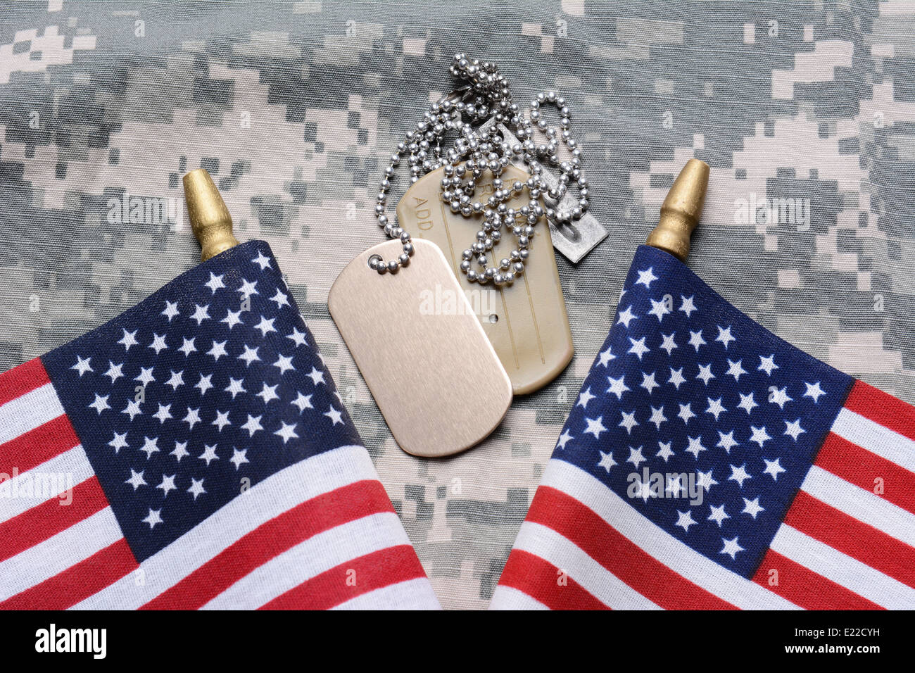 Nahaufnahme von zwei gekreuzten amerikanische Flaggen auf Tarnung Material mit Dog Tags in der Mitte. Stockfoto