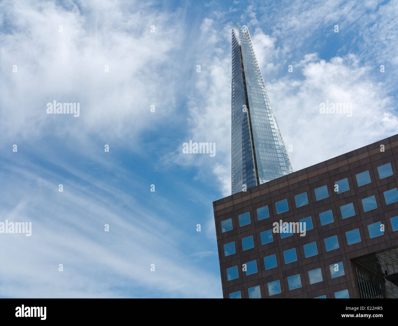 Weitwinkel von The London Shard mit Bürogebäude mit Himmel gefüllt quadratischen Fenster im Vordergrund gegen blau-weißen Himmel Stockfoto