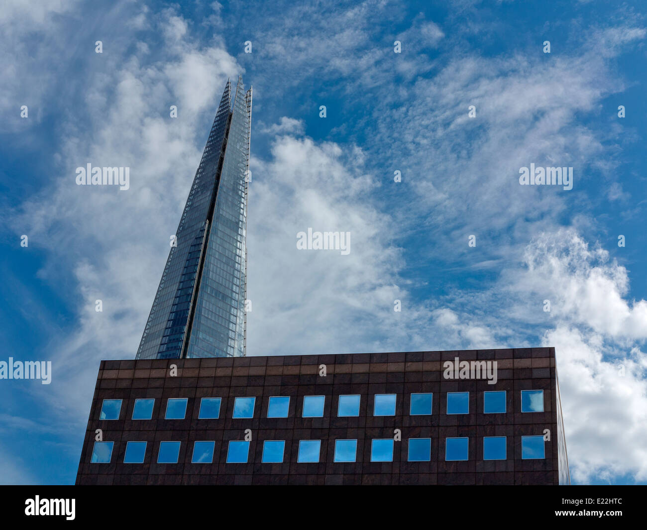 Weitwinkel von The London Shard mit Bürogebäude mit Himmel gefüllt quadratischen Fenster im Vordergrund gegen blau-weißen Himmel Stockfoto