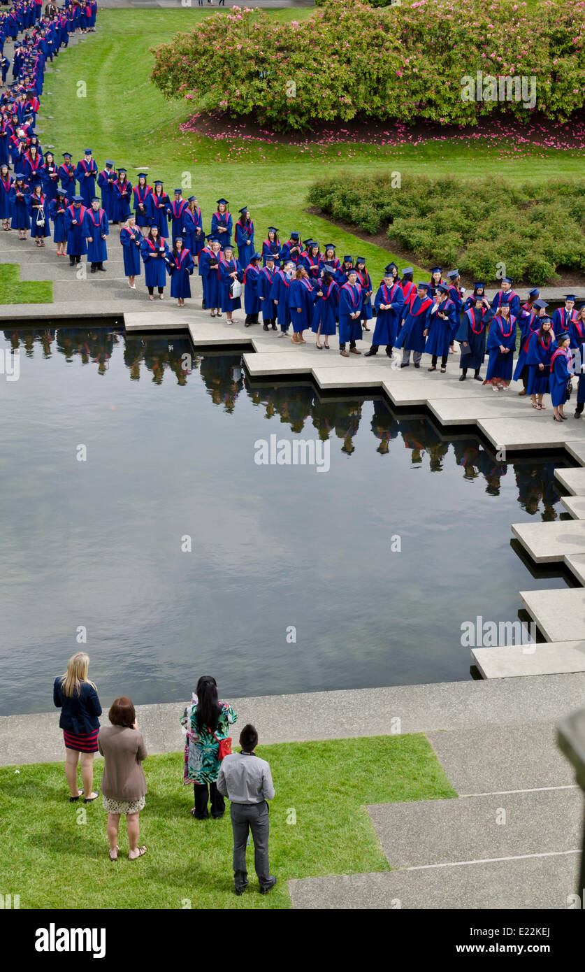 BURNABY, BC, KANADA.  12. Juni 2014: Simon Fraser University Studenten stehen am Teich im akademischen Viereck kurz vor Beginn der feierlichen Frühjahr 2014 Einberufung für die Fakultät für Geistes- und Sozialwissenschaften. Stockfoto