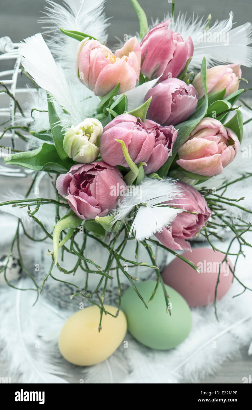 Oster-Deko mit rosa Tulpe Blumen und gefärbten Eiern Stockfoto