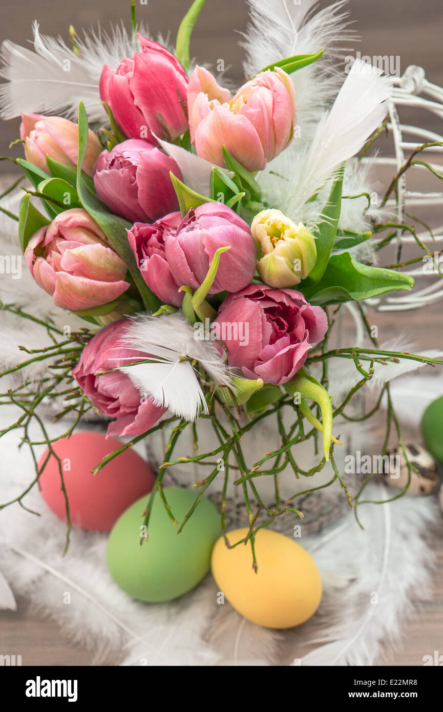 Oster-Deko mit rosa Tulpe Blumen und gefärbten Eiern Stockfoto