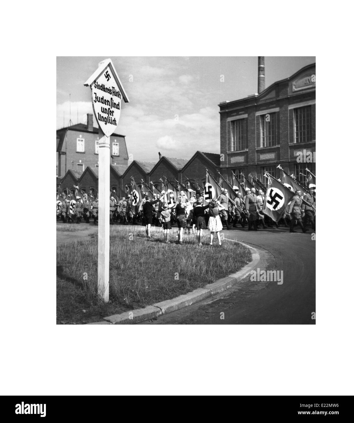 1930er Jahren parade Deutschland mit Kindern ein Hakenkreuz-Flagge salutieren und winkt ein marschieren in Nürnberg Stockfoto