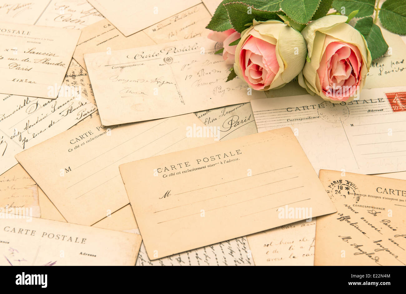 Antike französische Postkarten und Rosenblüten. Carte Postale aus Paris. nostalgisch romantische Hintergrund Stockfoto