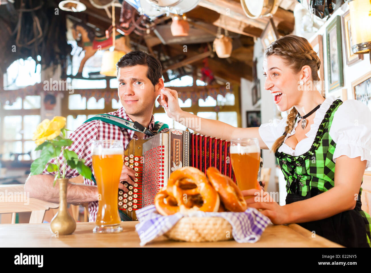 Bayerischen Mann spielt Volksmusik für Frau trägt dirndl Stockfoto