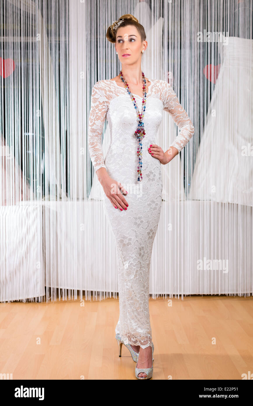 Frau versucht auf Hochzeitskleid oder Brautkleid im Hochzeit Fashion store Stockfoto