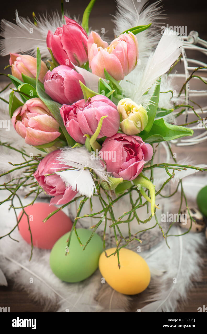 Oster-Deko mit rosa Tulpe Blumen und gefärbten Eiern Stockfoto