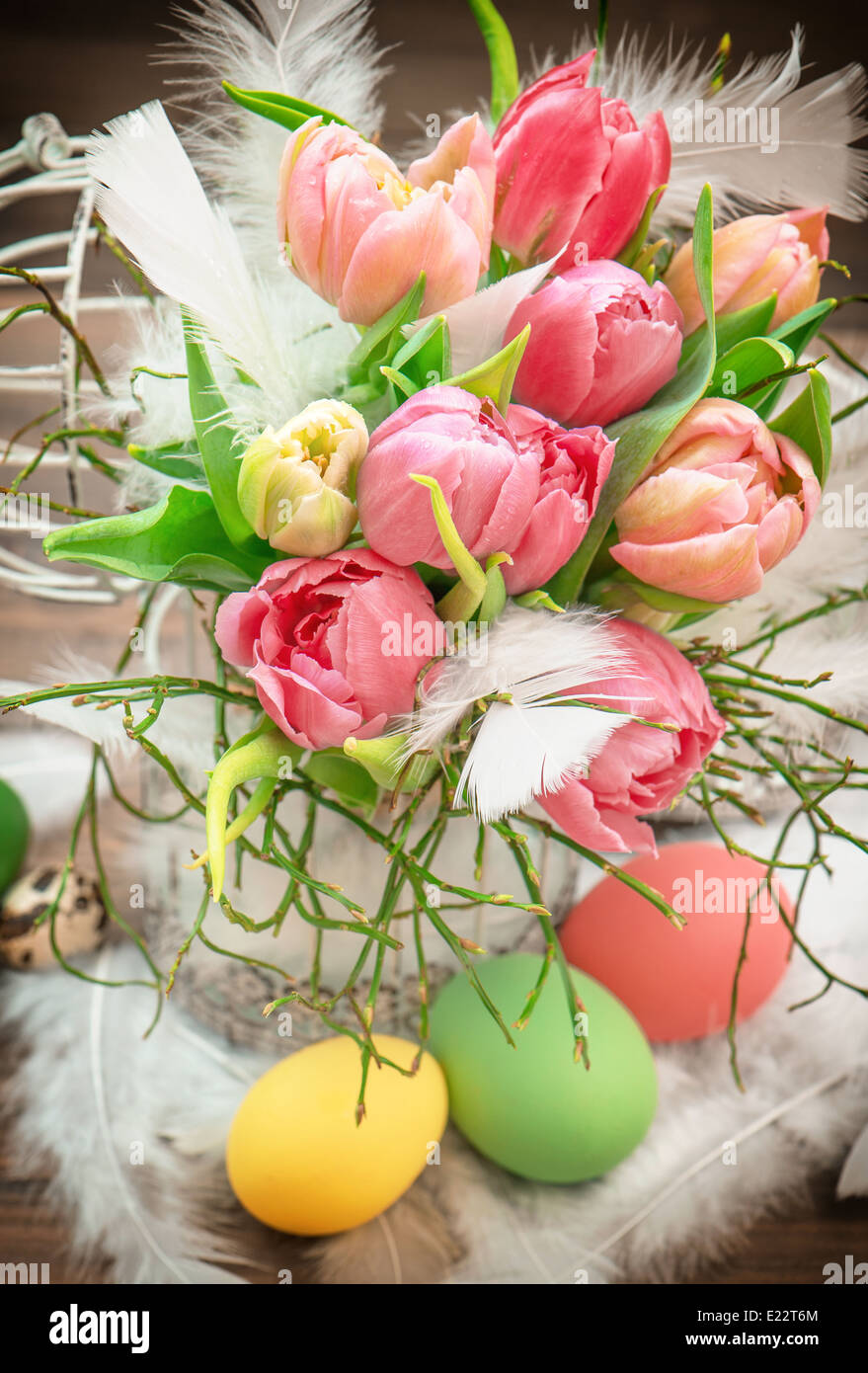 Oster-Deko mit rosa Tulpe Blumen und bemalten Eiern. leuchtende Farben Stockfoto