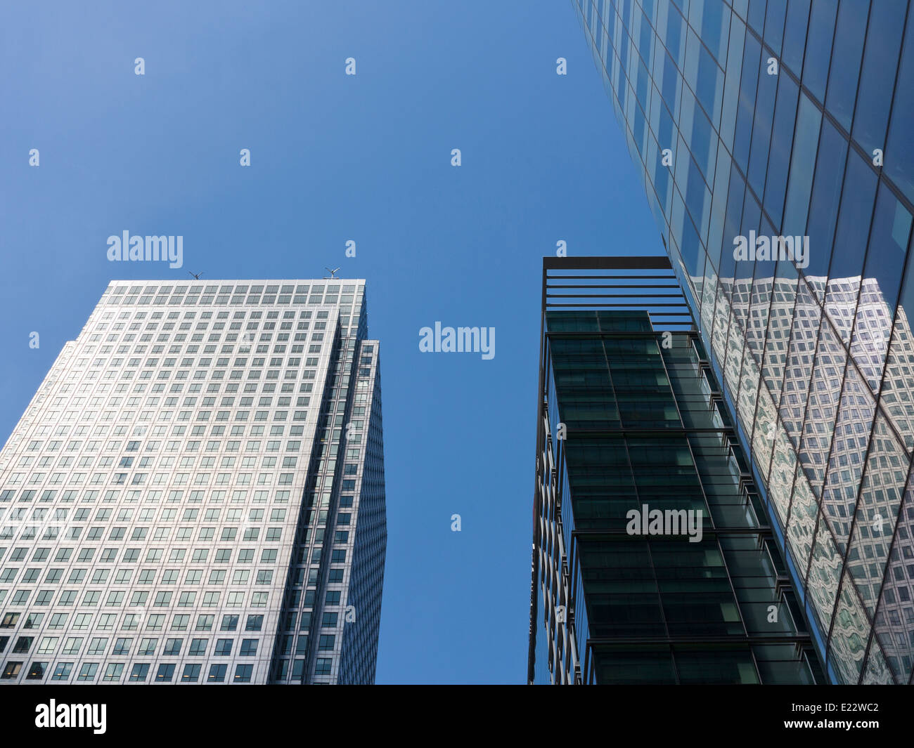 Blickte zu modernen Glas und Stahl stark reflektierende kommerzielle Wolkenkratzer gegen ein strahlend blauer Himmel mit Wolken Licht wight Stockfoto