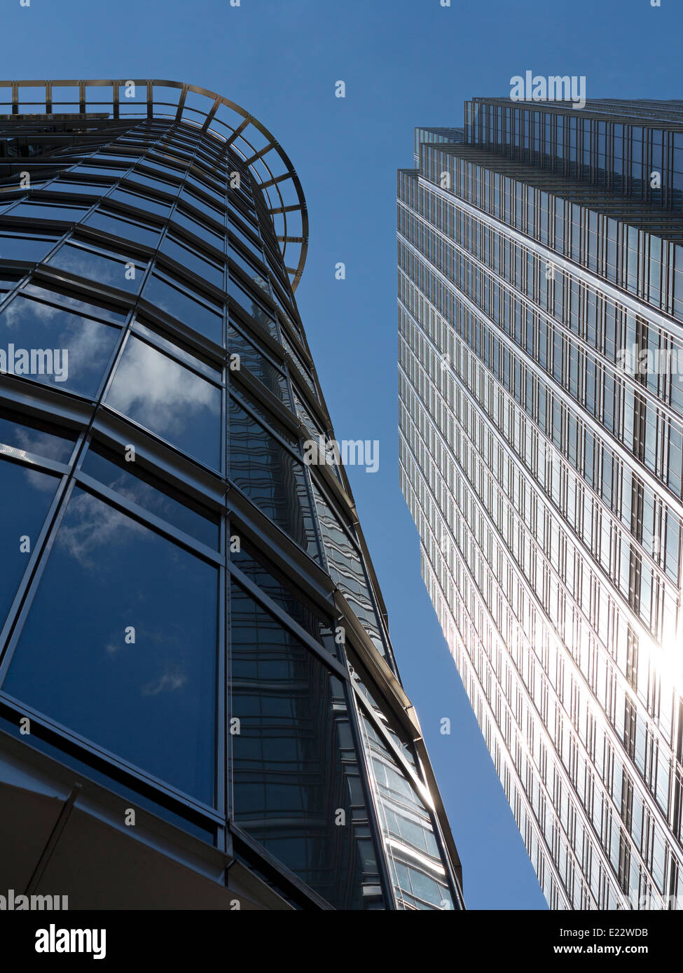 Blickte zu modernen Glas und Stahl stark reflektierende kommerzielle Wolkenkratzer gegen ein strahlend blauer Himmel mit Wolken Licht wight Stockfoto