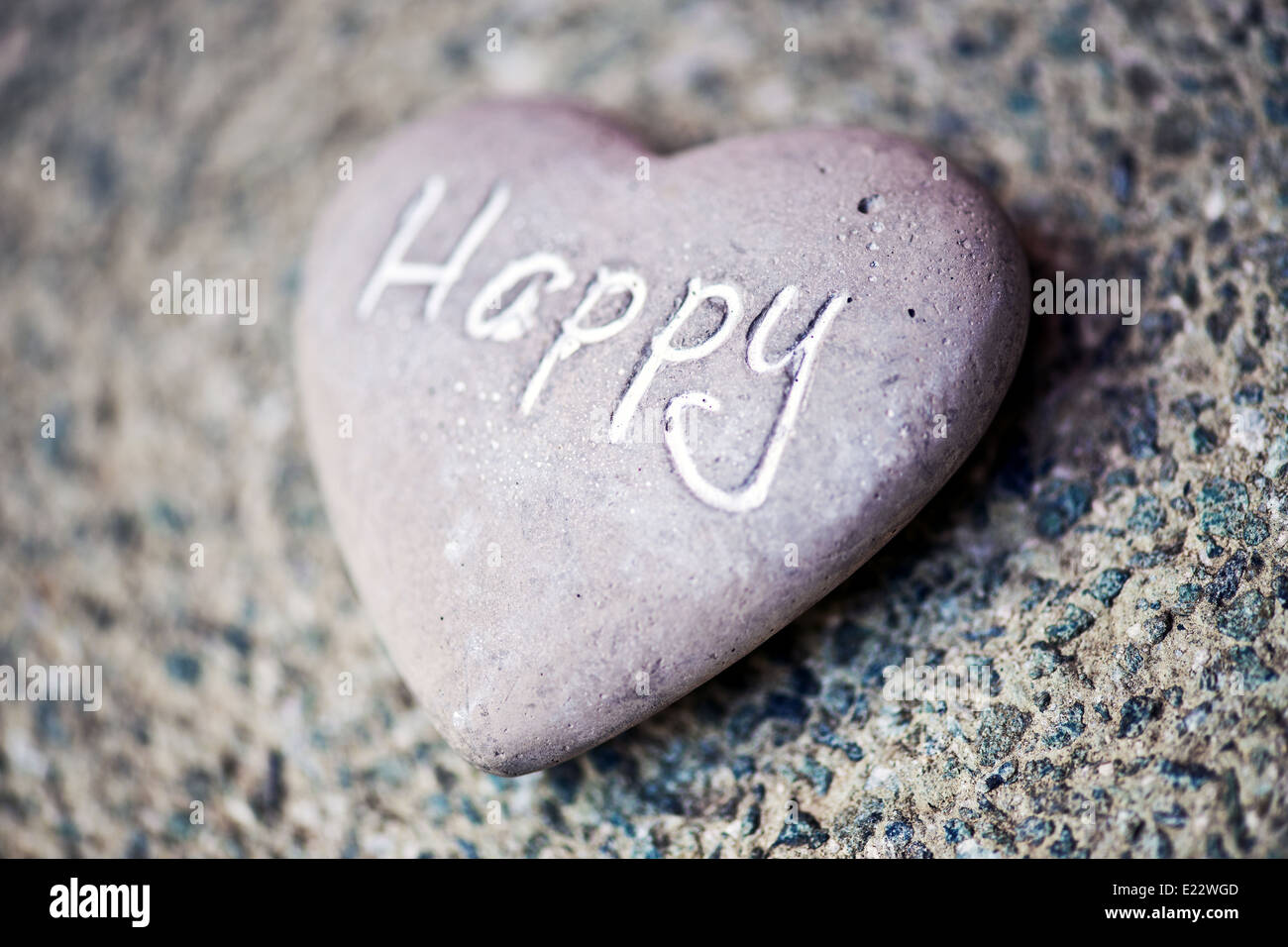 Stein Herz mit dem Wort - glücklich Stockfoto