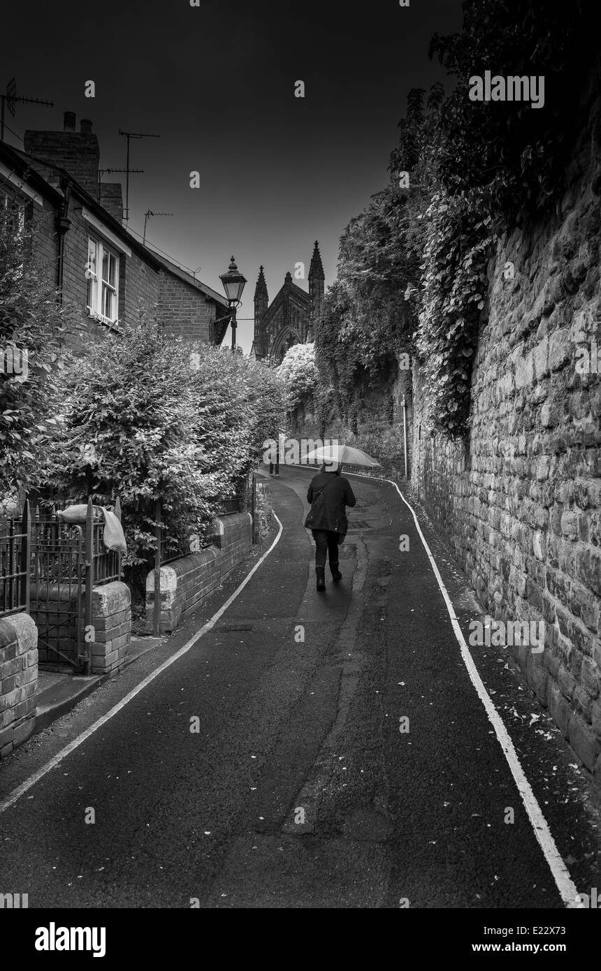 Ein weiterer Regentag in Hereford UK mit einer Dame, die ihren Weg in die Einkaufsstadt Stockfoto