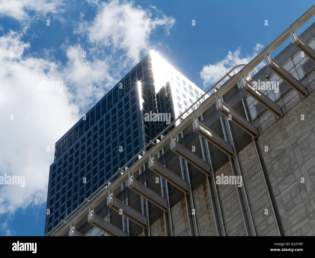 Blickte zu modernen Glas und Stahl stark reflektierende kommerzielle Wolkenkratzer gegen ein strahlend blauer Himmel mit Wolken Licht wight Stockfoto