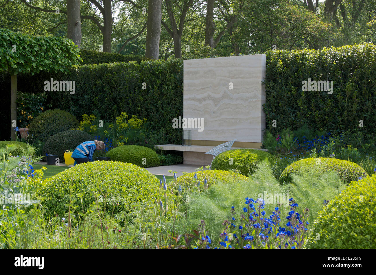 RHS Chelsea Flower Show 2014. Ein Gärtner wischt Blätter in The
