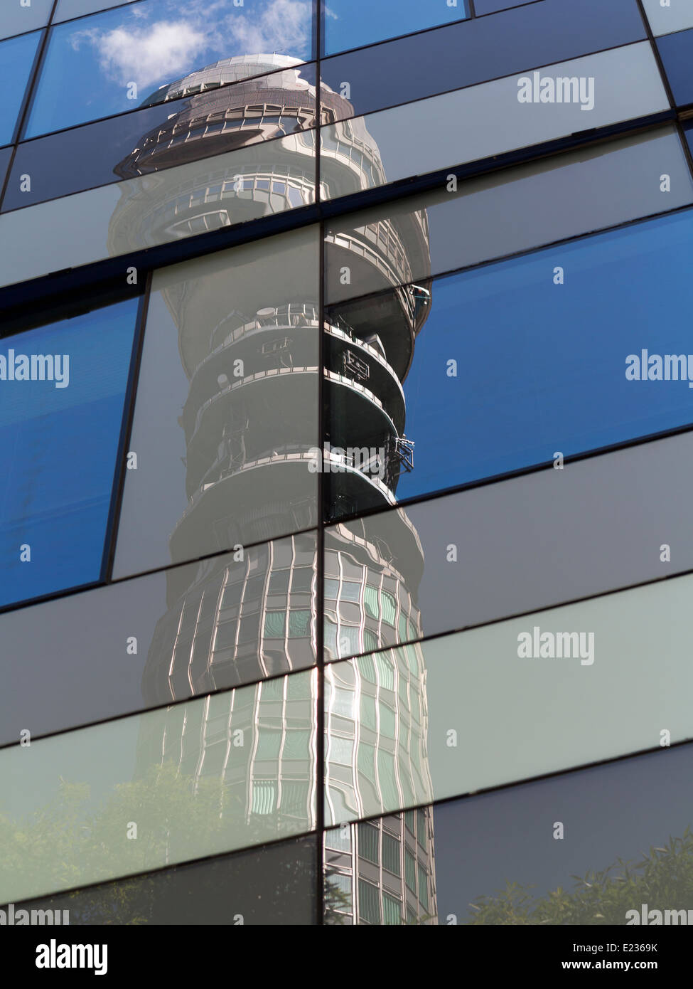 Telekom-Turm vor blauem Himmel mit weißen Wolken und Bäume. Im Fenster Spiegelungen auf kubistische Weise verzerrt Stockfoto