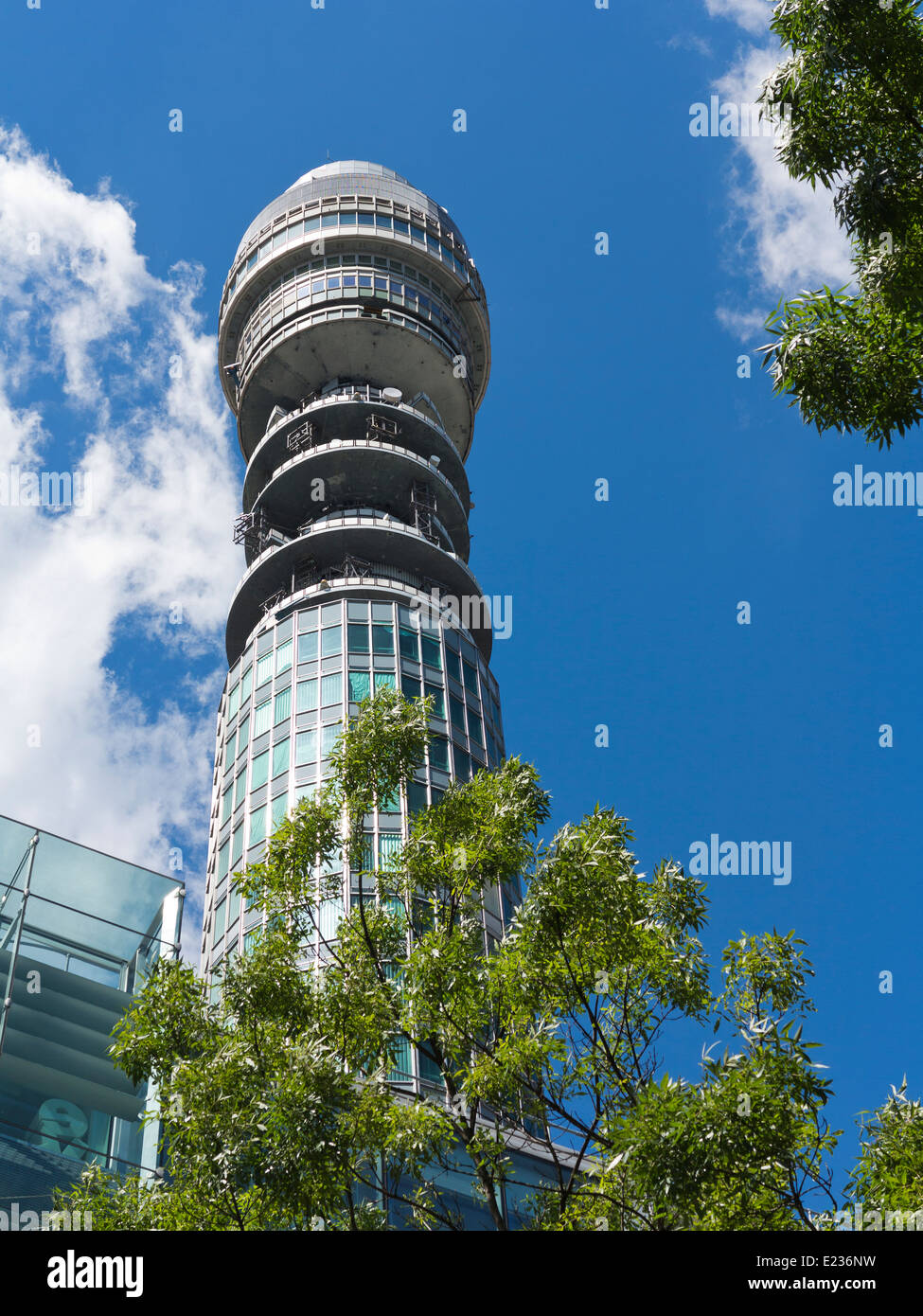 Telekom-Turm vor blauem Himmel mit weißen Wolken und Bäume Stockfoto