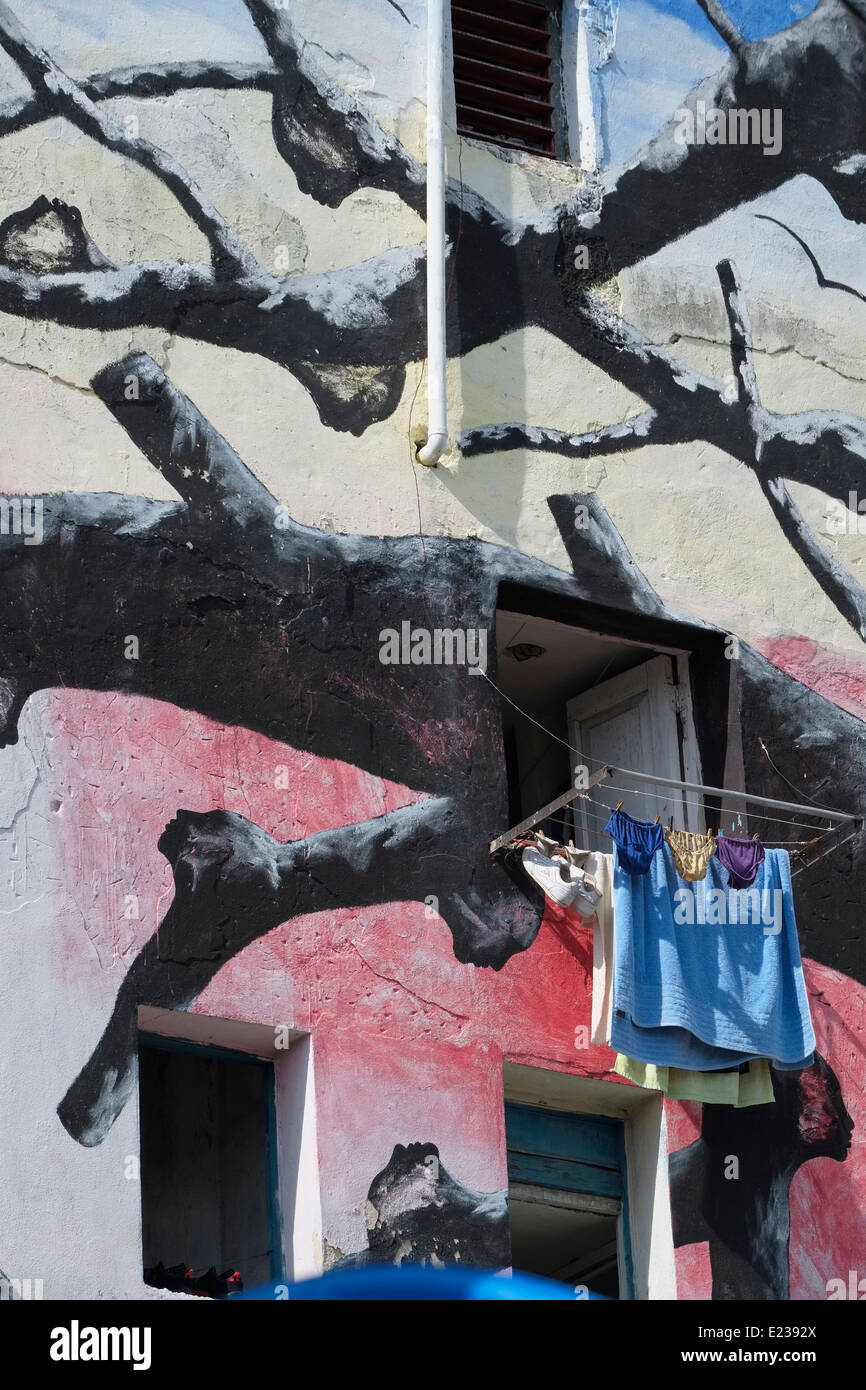 Windows und trocknende Wäsche auf einem bemalten Gebäude im Callejón de Hamel, zentralen Havanna, Kuba. Stockfoto