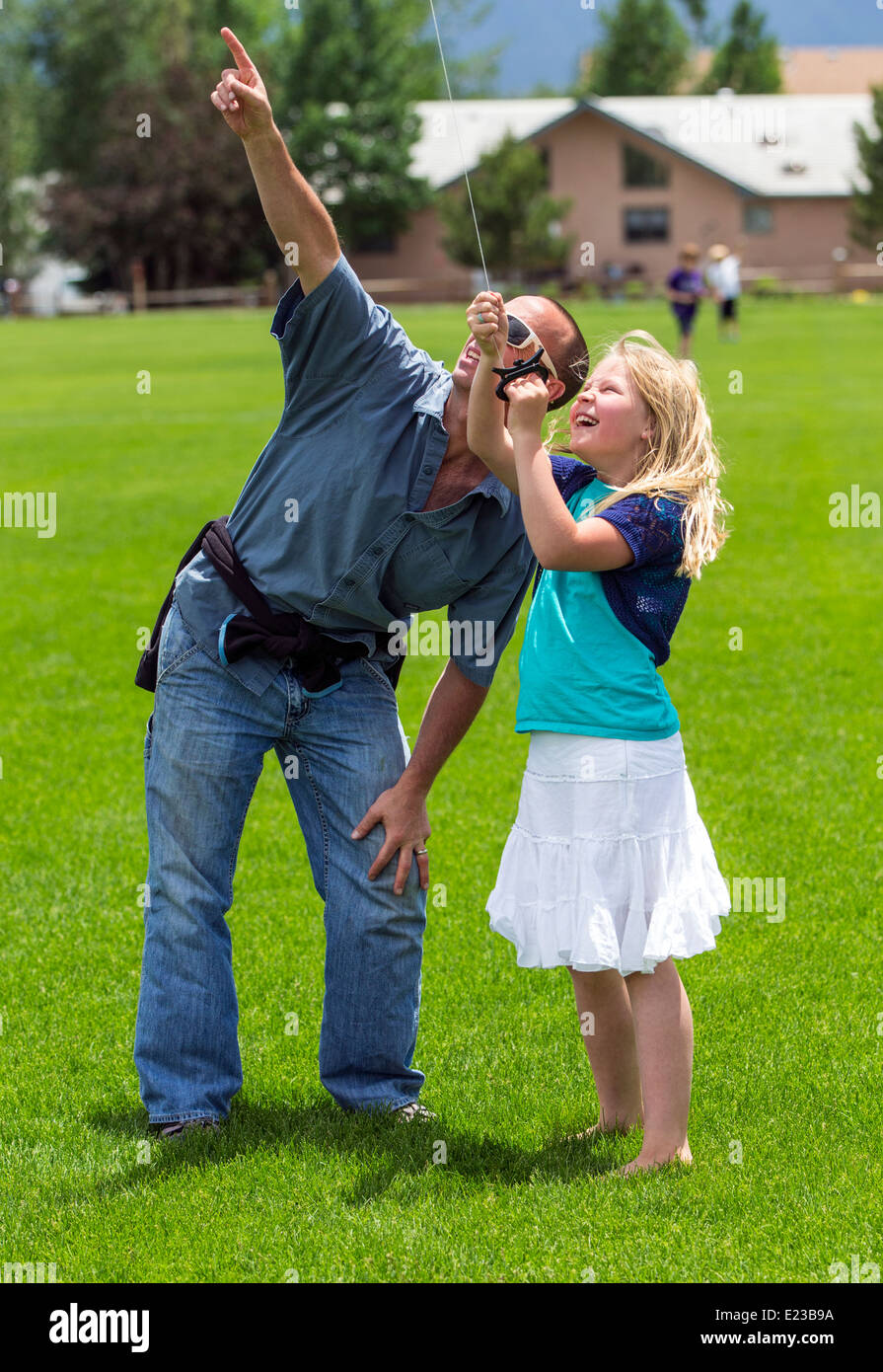 Vater & junge Tochter eines Drachen auf einer Wiese Stockfoto