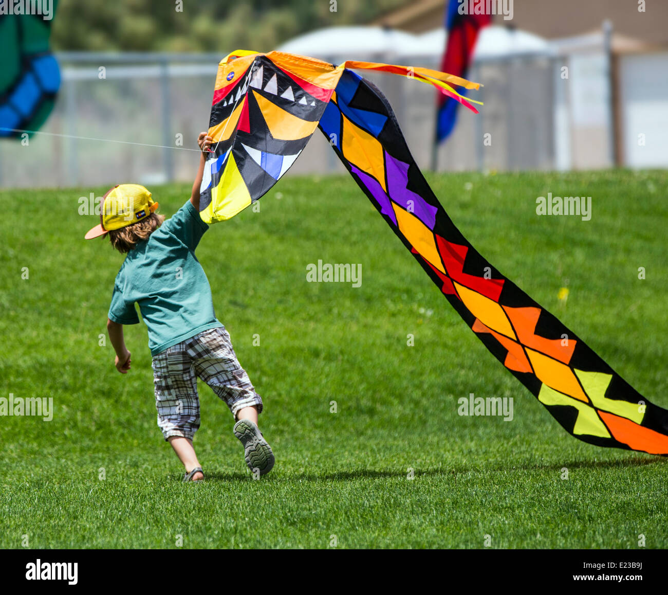 Kleiner Junge einen Drachen auf einer Wiese zu starten Stockfoto