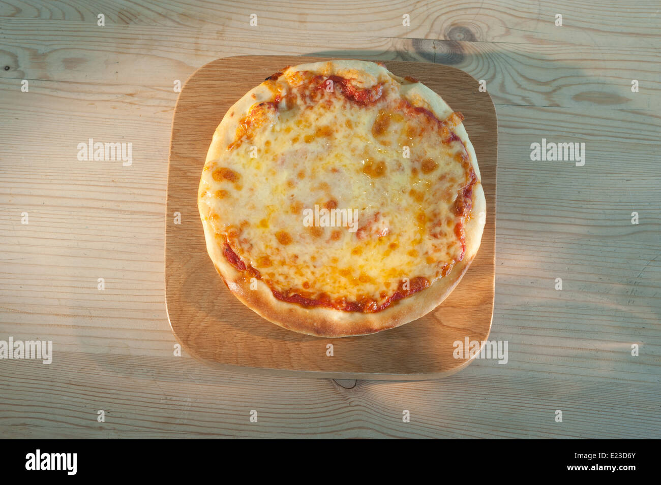 Pizza auf einem hölzernen Teller serviert. Margherita mit Tomaten-Mozzarella-Käse und Basilikum. Stockfoto
