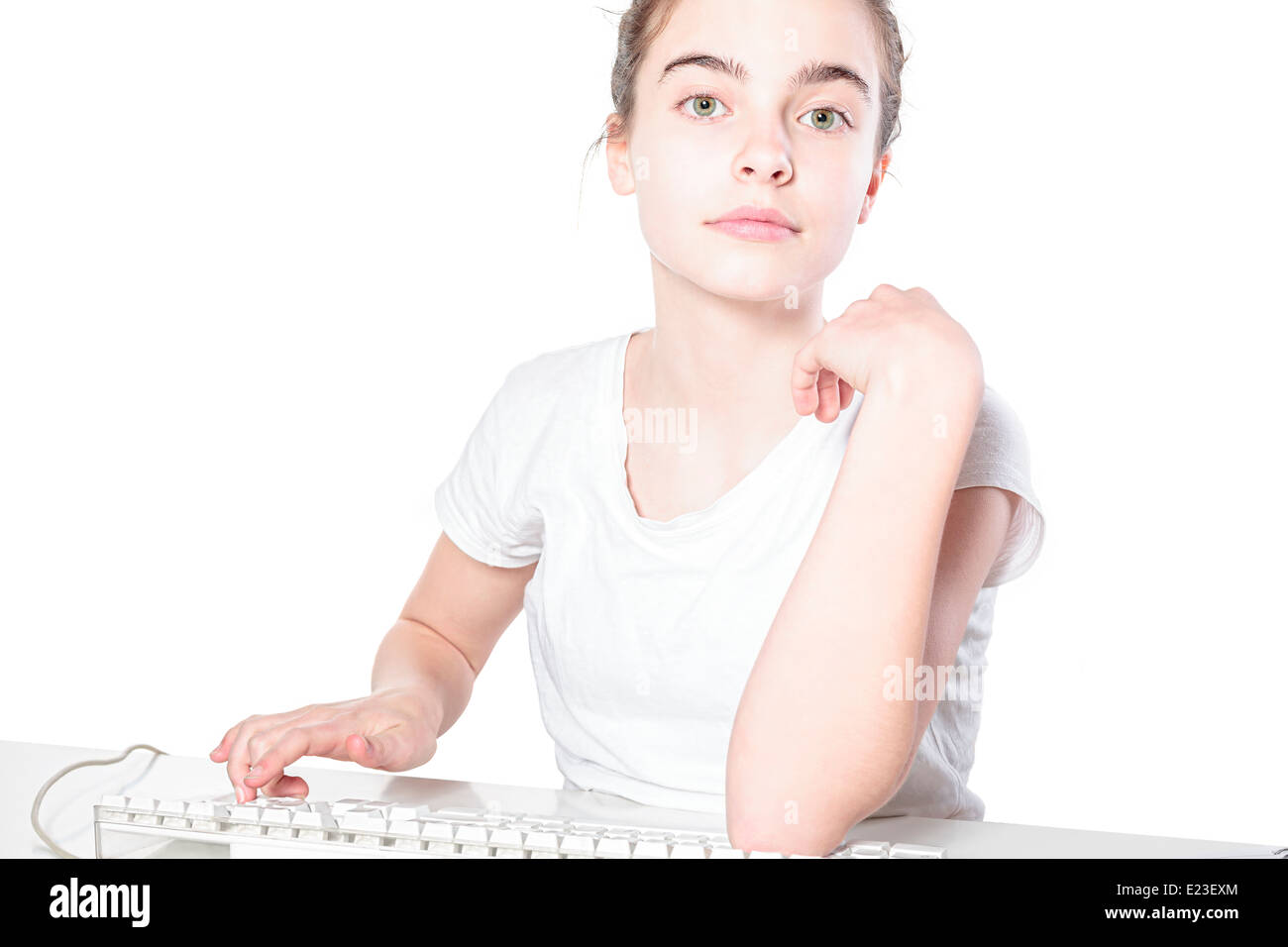 Lächeln Teenager-Mädchen, die an einer Tastatur arbeiten, isoliert auf weiss. Stockfoto