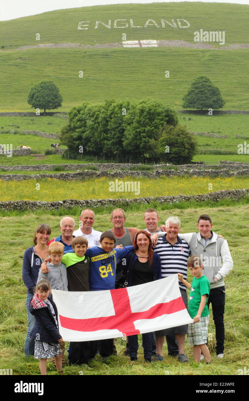 Peak District, Derbyshire, UK.  15. Juni 2014.  Mitglieder einer Gruppe von 15 Dorfbewohner, die ein Zeichen auf einem Hügel über dem Dorf Chelmorton in der Nähe von Buxton geschaffen haben.  Lokalen resident Phil Swindell, 44, bleibt optimistisch über Englands Chancen trotz ihrer Niederlage gegen Italien.  Der Baumeister sagte: "Ich denke wir haben in Ordnung, aber das macht es sehr schwer.  Wir werden in Ordnung.  Optimisten sind wir nicht." Bildnachweis: Matthew Taylor/Alamy Live-Nachrichten Stockfoto