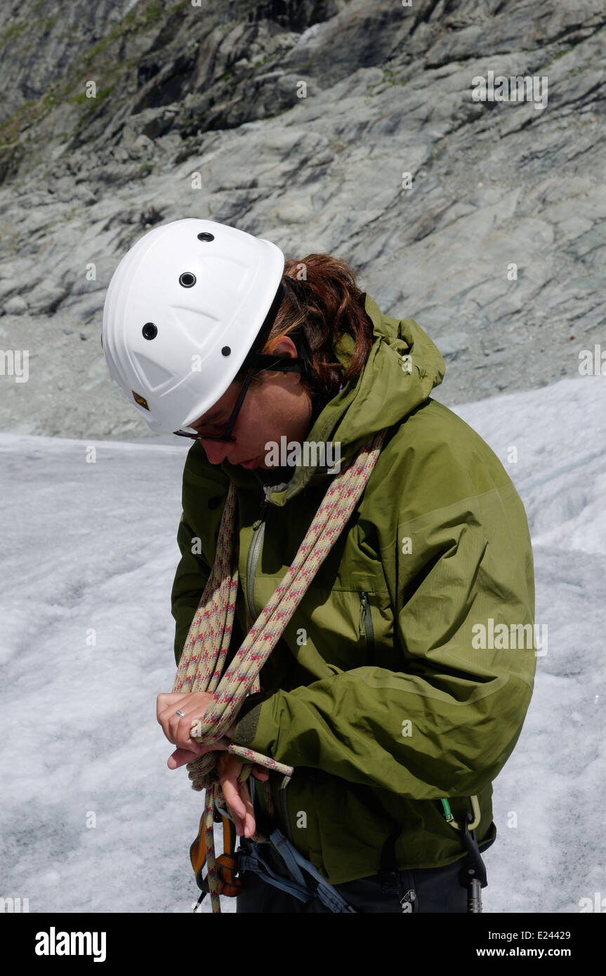 Eine Dame Bergsteiger üben binden Knoten in einem Kletterseil auf einem alpinen Kletterkurs am Ferpecle Gletscher, Schweizer Alpen Stockfoto