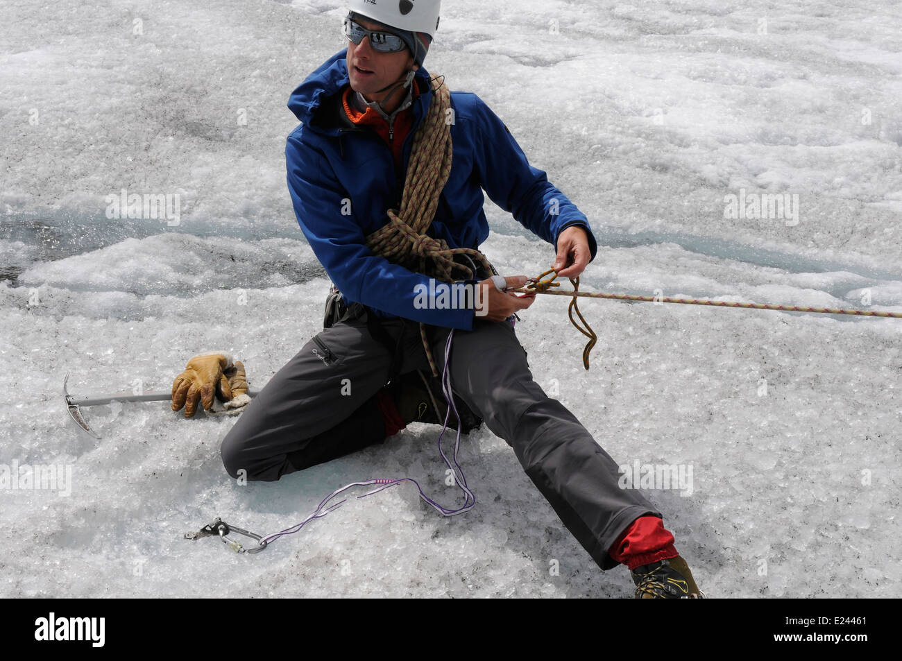 Bergführer zeigt, so dass ein Prusik-Knoten und ein Seil für Spaltenbergung auf einem alpinen Kletterkurs einrichten Stockfoto