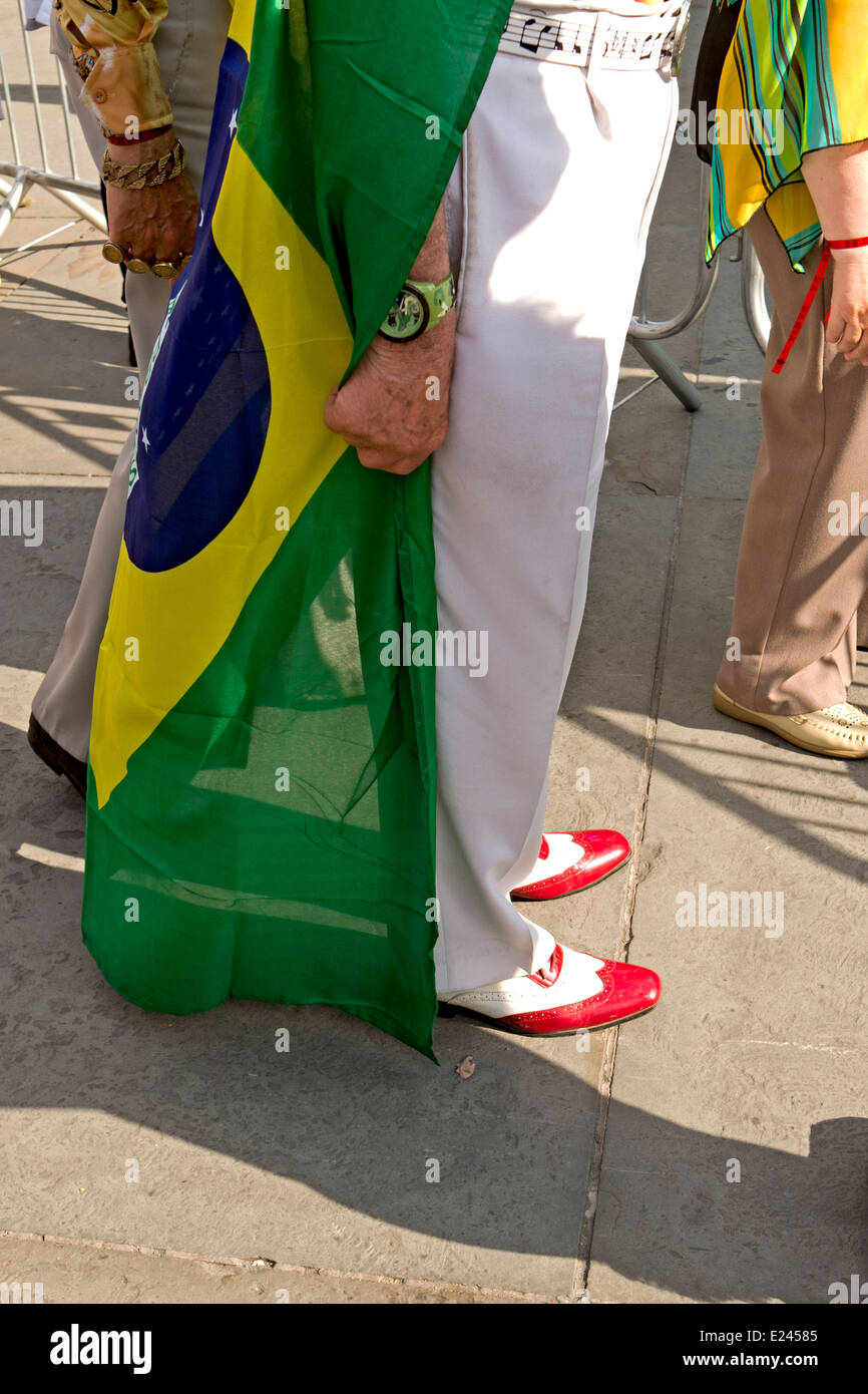 Ein Mann in schicke Schuhe mit der brasilianischen Flagge drapiert um ihn bei den Feierlichkeiten am Trafalgar Square in Brasilien. Stockfoto