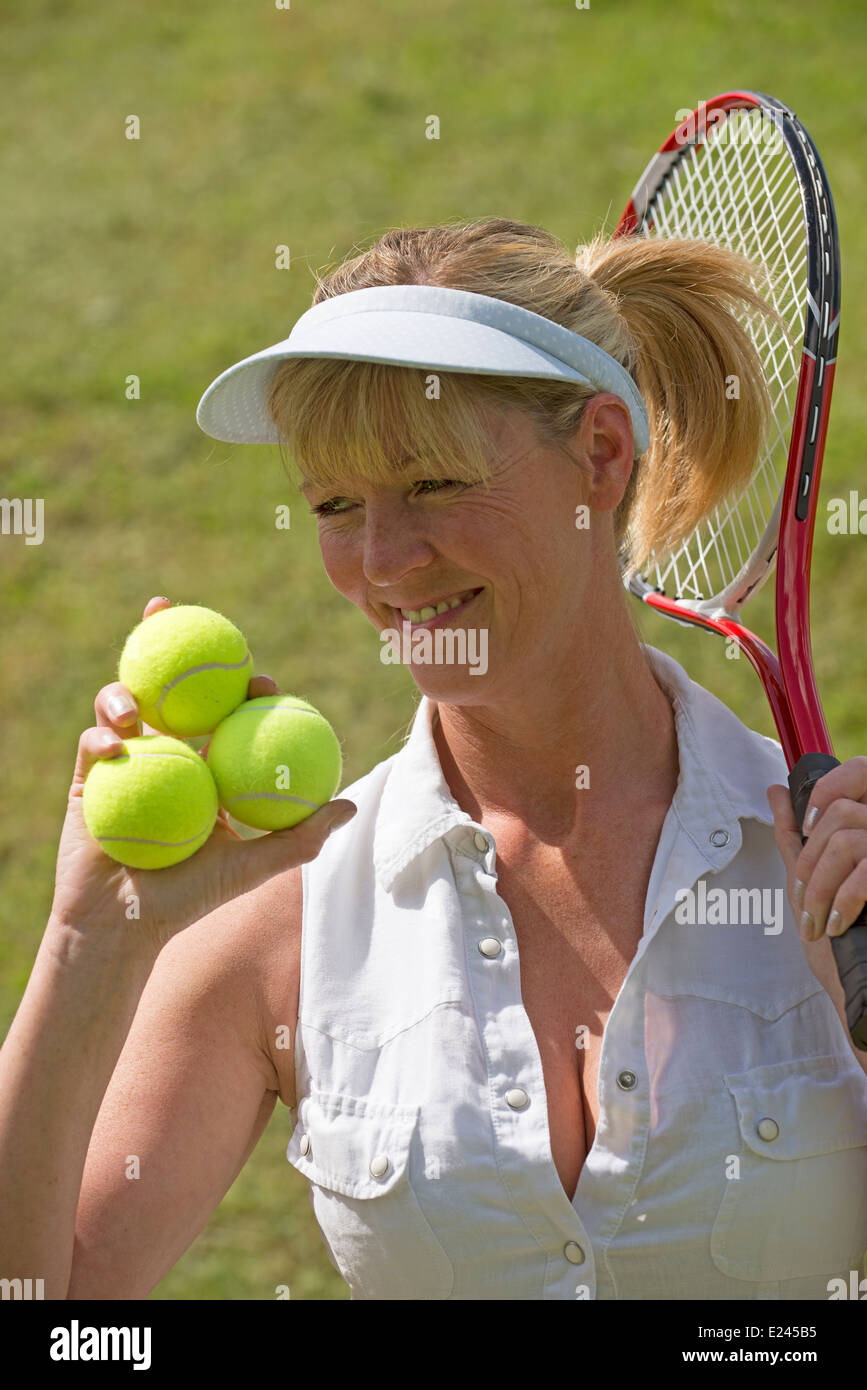 Tennisspielerin mit Schläger und drei Kugeln in der hand Stockfoto