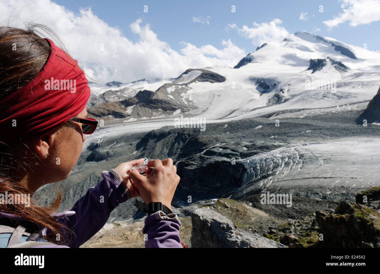 Eine Dame Kletterer nehmen eine Sichtung bis zum Gipfel des das Strahlhorn in den Schweizer Alpen, die Route für die nächsten Tage Aufstieg vorbereiten Stockfoto