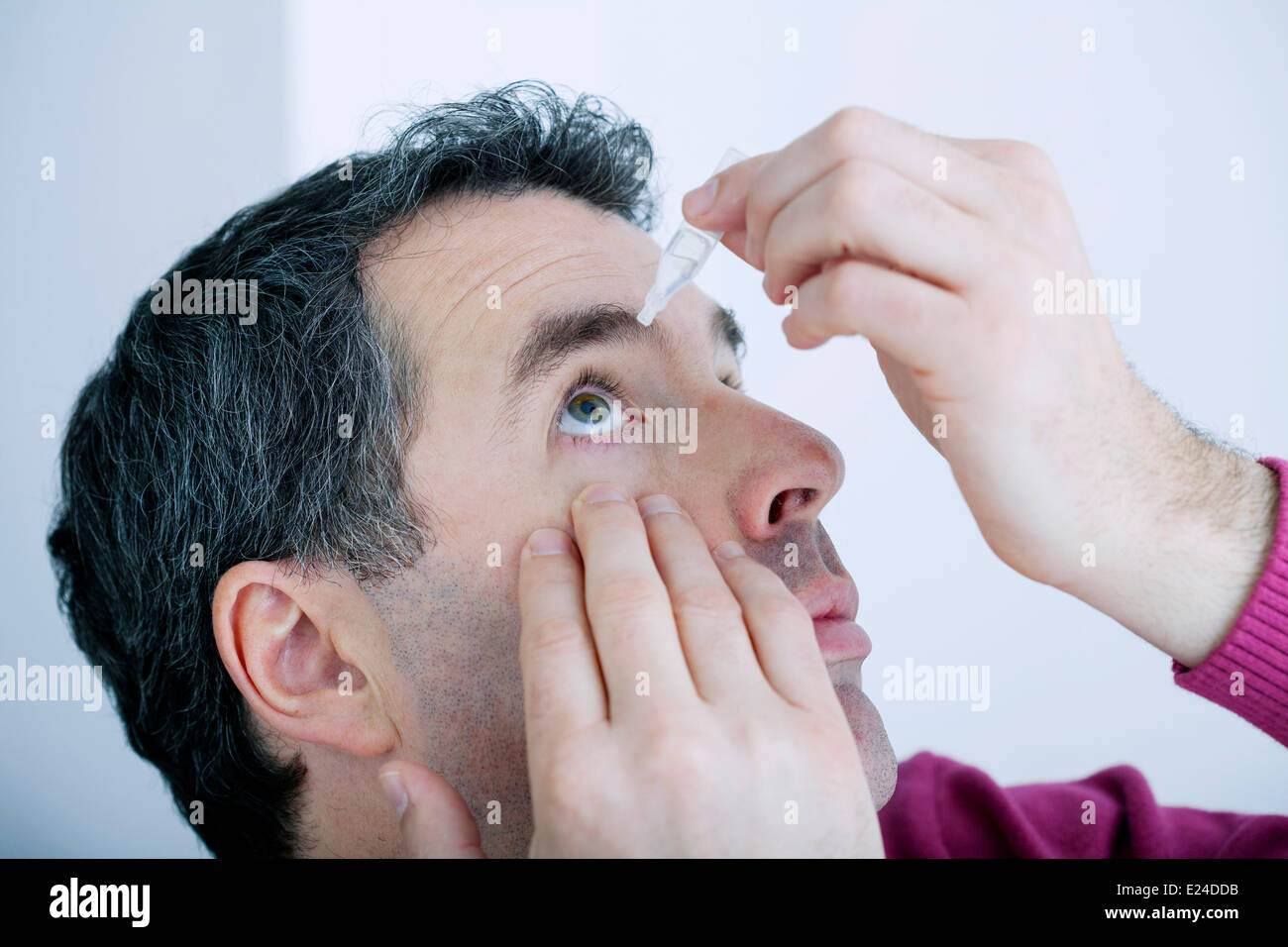 Mann mit Auge lotion Stockfoto