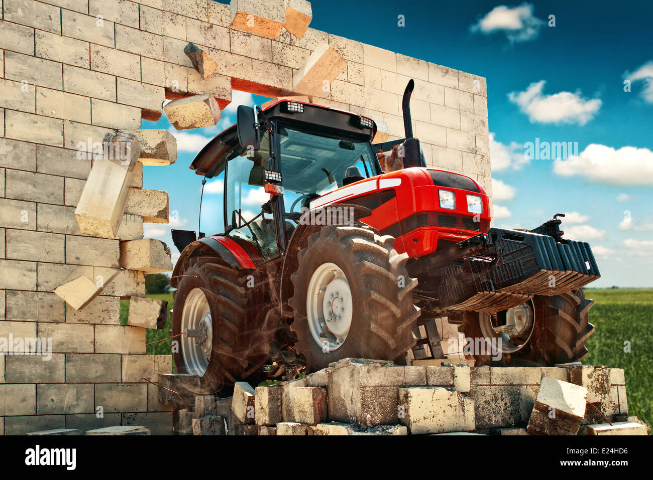 Landwirtschaftliche Zugmaschine, die Mauer zu durchbrechen. Stockfoto