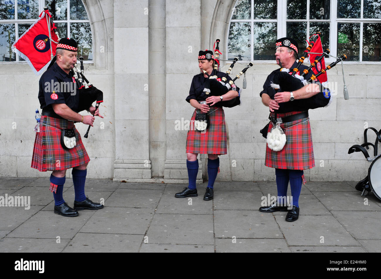 Drei Mitglieder der Feuerwehren Union Schottland spielen Dudelsack während einer Protestaktion gegen Kürzungen, London, UK Stockfoto